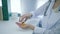 Dietitian hands opens vial of vitamins and pours yellow round pills into palm on white table