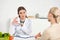 Dietitian in white coat holding pills and patient