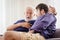 Differences of two generations male elder father with younger man son serious talking consulting together or telling history story