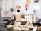 Different aged couple standing with box of turron in production workshop