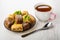 Different baklava in saucer, teaspoon, cup of tea on table