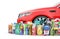 Different Bottles of car maintenance products near red car. Oil, detergents and lubricants.