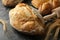 Different bread, spikelets and rolling pin on black smokey background