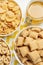 Different breakfast cereals and honey on white table, flat lay