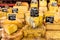 Different cheeses on the counter of a small store at the market.