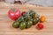 Different cherry tomatoes and ordinary tomato on wooden cutting board