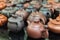 Different Chinese clay teapots stand on a counter in a tea shop