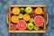Different citrus fruit on a wooden box and grey concrete table. Food background. Healthy eating. Antioxidant, detox