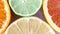 Different citrus slices, orange, lemon, lime and grapefruit, flat lay top view panning shot