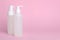 Different cleansers on pink background, space for text. Cosmetic product
