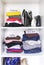 Different clothes in home wardrobe with paper notes. Small space organization. Vertical storage