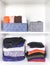 Different clothes in home wardrobe with paper notes. Small space organization. Vertical storage