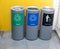 Different color trash cans in row for waste management.