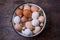 Different colored chicken and quail eggs in an old tray