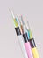 Different colored fiber optic cable ends with stripped jacket layers and exposed colored fibers