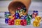 Different colored game dices and a dice cup on a wooden table