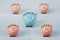 Different colored piggy bank standing out of the crowd. The uniqueness and leadership concept, individuality and difference.