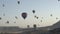 Different colourful hot air balloons fly over mountains