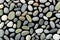 Different colourful small sea stones isolated on black background. Background of sea stones. Ocean stones isolated