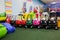 Different colourful toy cars are standing in children entertainment center in a line. Games for small kids.