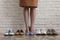 Different comfortable footwear near woman wearing high heeled shoes indoors, closeup