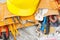 Different construction tools and a helmet, wooden background