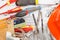 Different construction tools and a helmet, wooden background