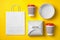 Different containers for mock up design on yellow background, flat lay.