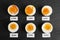 Different cooking time and readiness stages of boiled chicken eggs on black table