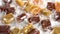 Different cream colored toffee candies in wrappers on a white plate. Macro.