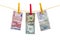 Different currency banknotes hanging on clothesline