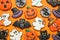 Different decorated gingerbread cookies on orange background. Halloween celebration