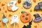 Different decorated gingerbread cookies on yellow background. Halloween celebration