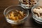 Different dietary supplements in glass bowls on wooden table, closeup