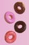 Different donuts fly on a pink background