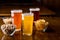 Different drinks in glasses. Pistachios, chips, peanuts in glass in plates on wooden table