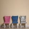 Different elegant chairs near beige wall