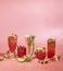 Different elegant glasses with watermelon cocktail. Splash, splatter, water drops on the pink background with sun light