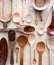 Different empty kitchen spoons made of different woods, top view