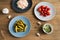 Different fermenting foods in plates. Homemade sauerkraut with marinated cucumbers and tomatoes on wooden background