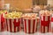 Different flavors of popcorn in branded paper cups of different sizes, family movie