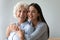 Different generations relatives women embracing posing looking at camera