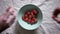 Different hands taking strawberries from bowl