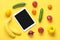 Different health food -  bell pepper, tomatoes, bananas, green cucumber, onions, lemon, tablet with black screen on yellow backgro