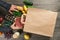 Different healthy food on wooden table with paper bag