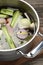 Different ingredients for cooking tasty bouillon in pot on wooden table, closeup