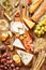 Different kinds of cheeses, wine, baguette, fruits and snacks