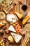 Different kinds of cheeses, wine, baguette, fruits and snacks