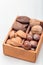 Different kinds of nuts in the shell: hazelnut, walnut, almond and brazil nuts in wooden box with nut cracker on background,
