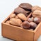 Different kinds of nuts in shell, hazelnut, walnut, almond and brazil nuts in  wooden box, square format